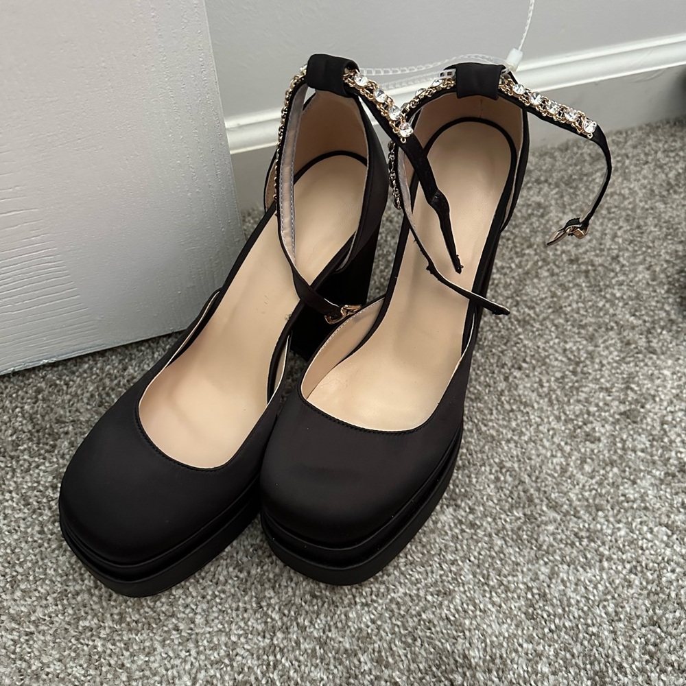 Satin black platform heels with rhinestone covered gold ankle straps
